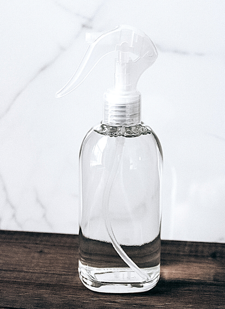 glass spray bottle on wooden surface