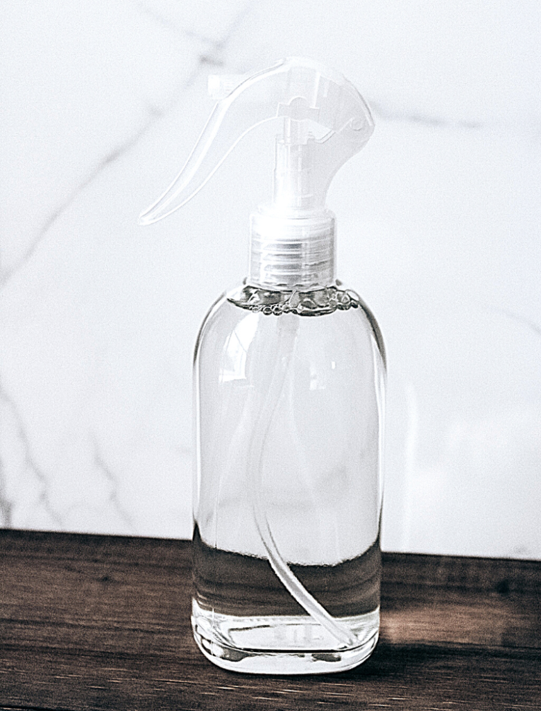 glass spray bottle on wooden surface