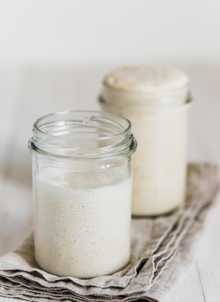 Glass mason jar of sourdough starter set as the featured image in this post.