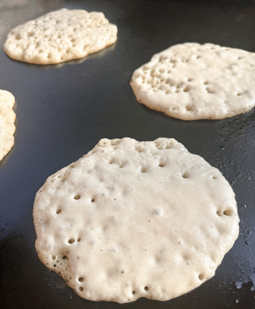 uncooked pancakes showing bubbles